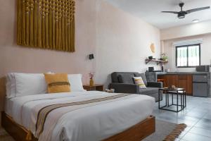 a bedroom with a bed and a living room at Rodina Boutique Hotel in Playa del Carmen
