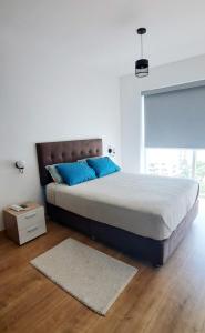 a bedroom with a bed with blue pillows and a rug at VK Loft - Apartamento en Miraflores in Lima