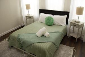 Cozy Getaway في Everett: غرفة نوم بسرير اخضر مع وسادتين
