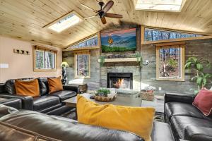 a living room with leather furniture and a fireplace at Whispering Winds in Gatlinburg