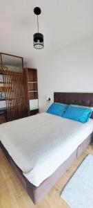 a bedroom with a large bed with blue pillows at VK Loft - Apartamento en Miraflores in Lima