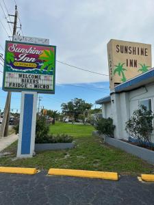 un panneau devant un magasin de ligne solaire avec un bâtiment dans l'établissement Sunshine Inn of Daytona Beach, à Daytona Beach