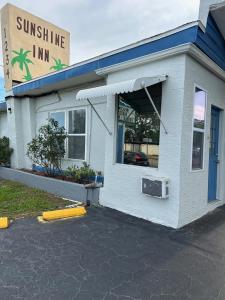 ein sonnendurchflutetes Gastgebäude mit einem Schild darauf in der Unterkunft Sunshine Inn of Daytona Beach in Daytona Beach