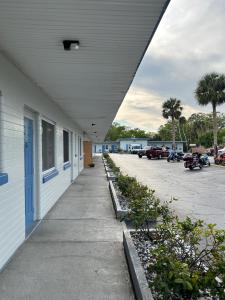 un bâtiment avec un trottoir à côté d'un parking dans l'établissement Sunshine Inn of Daytona Beach, à Daytona Beach