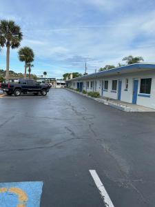 Ein schwarzer Truck parkt auf einem Parkplatz neben Gebäuden. in der Unterkunft Sunshine Inn of Daytona Beach in Daytona Beach
