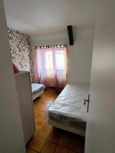 a small room with a bed and a window at La Grange de Lili in Figeac