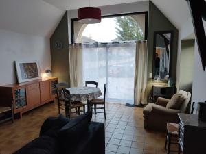 een woonkamer met een tafel en stoelen en een raam bij La Grange de Lili in Figeac