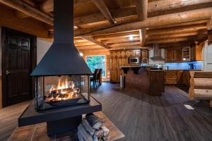 Cabaña de madera con sala de estar con chimenea en Les Chalets Tourisma - Chalet en bois rond avec spa et lac privé - Le Caribou en Sainte-Catherine