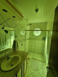 W łazience znajduje się zielona umywalka i toaleta. w obiekcie CASA DO PINHEIRO w mieście Chapecó
