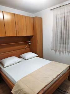 - une chambre avec un grand lit et une tête de lit en bois dans l'établissement Apartments with a parking space Biograd na Moru, Biograd - 20756, à Biograd na Moru