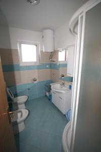 La salle de bains est pourvue de 2 toilettes et d'un lavabo. dans l'établissement Apartments with a parking space Biograd na Moru, Biograd - 20756, à Biograd na Moru