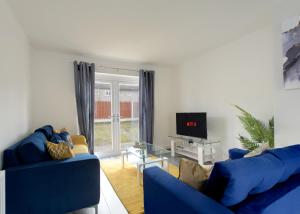 sala de estar con 2 sofás azules y TV en Free Parking Large House Huyton Golf Club M57, en Roby