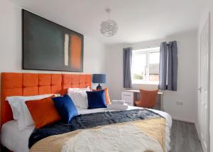 1 dormitorio con 1 cama grande y cabecero naranja en Free Parking Large House Huyton Golf Club M57, en Roby