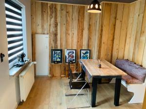 a dining room with a table and chairs and wooden walls at Luhne Boutique Pension in Rotenburg an der Wümme