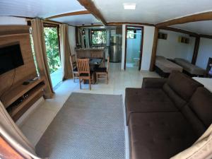 a living room with a couch and a table at Chalé e Suite Manacá in Ubatuba