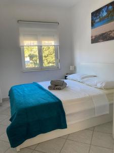 a bedroom with two beds with a blue blanket on it at Sea View Apartments in Grebaštica