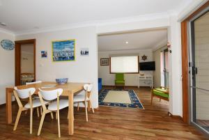 a dining room with a table and chairs at Aqua Vincentia - Belle Escapes Jervis Bay in Vincentia