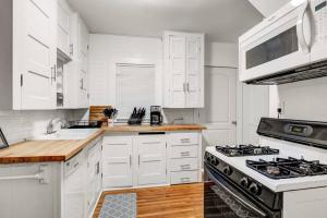a kitchen with white cabinets and a stove top oven at Cozy Cuse home close to downtown and University in Syracuse