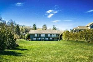 una casa grande en un campo verde con un patio en Romeo Resort -Waterfront-, en Wiarton