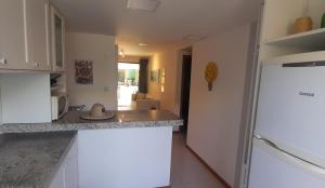 a kitchen with a counter top and a refrigerator at Village Pé na Areia - Itacimirim in Itacimirim