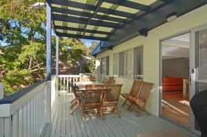 a patio with a table and chairs on a deck at Pipers Run - Belle Escapes Jervis Bay in Vincentia