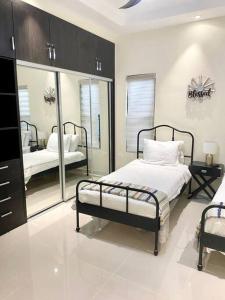 a bedroom with two beds and a mirror at Villa La Rosa with Spectacular view of Ocho Rios in Ocho Rios +54 photos