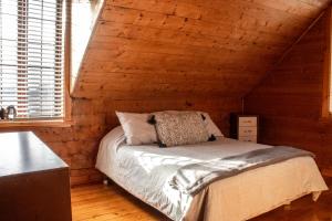 - une chambre avec un lit dans une cabane en rondins dans l'établissement Les Chalets Tourisma - Maison de campagne avec spa - La Campagnarde, à Saint-Raymond