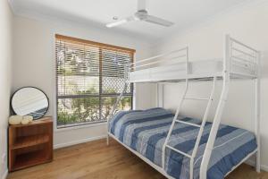 a bedroom with a bunk bed and a mirror at Villa Serene - Belle Escapes Jervis Bay in Vincentia