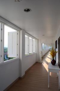 ホアヒンにあるSeapine Beach Golf and Resort Hua Hinの白い壁の廊下、窓、テーブル