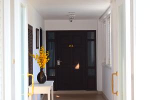 ホアヒンにあるSeapine Beach Golf and Resort Hua Hinの黄花の花瓶入り廊下の黒い扉