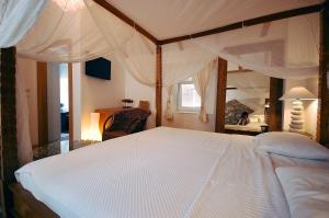 a bedroom with a large white bed and a mirror at Boutique Hotel Placa in Krk