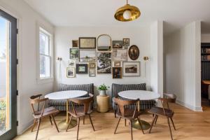 two tables and chairs in a dining room with photos on the wall at Magnolia Hotel in Jacksonville