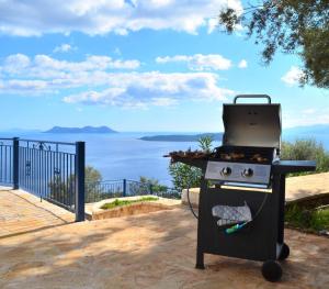 a barbecue grill with a view of the water at Villa Careva - Beautiful Cozy and Luxury Villa in Sivota