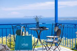 a table and chairs on a balcony with a view of the ocean at Villa Careva - Beautiful Cozy and Luxury Villa in Sivota