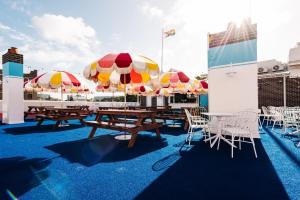 a patio with tables and chairs with umbrellas at The Lansdowne Hotel in Sydney