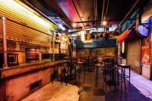 a bar with a bunch of stools in a room at The Lansdowne Hotel in Sydney