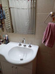 a bathroom with a white sink and a mirror at Casa de Lago y Montaña in El Calafate