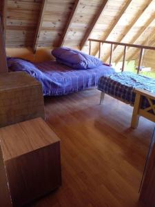 a attic room with two beds and a table at Casa de Lago y Montaña in El Calafate