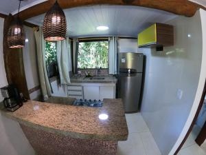 an rv kitchen with a counter and a refrigerator at Chalé e Suite Manacá in Ubatuba +63 photos