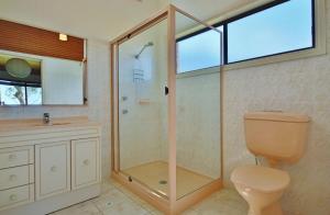 Un baño con ducha, inodoro y lavabo. en Absolute Waterfront - Belle Escapes Jervis Bay, en St Georges Basin