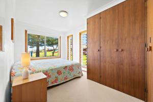 a bedroom with a bed and a large window at 3 Bay Lane in Narooma