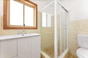 a bathroom with a toilet and a sink and a shower at 3 Bay Lane in Narooma +19 photos