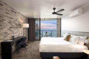 レッドクリフにあるThe Sebel Brisbane Margate Beachのベッド付きのホテルルームで、海の景色を望めます。
