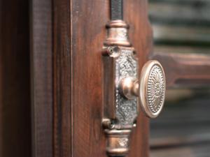 a wooden door with a brass door knocker on it at Chateau d'Angkor La Residence in Siem Reap