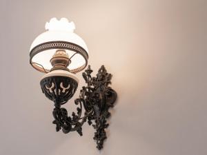 a lamp on a wall with a white wall at Chateau d'Angkor La Residence in Siem Reap