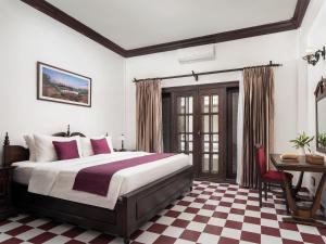 a bedroom with a bed and a checkered floor at Chateau d'Angkor La Residence in Siem Reap