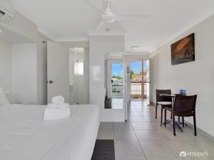 a bedroom with a bed and a table and chairs at Studio 20 ENDEAVOUR INN in Emu Park