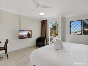 a bedroom with a bed and a desk and a window at Studio 20 ENDEAVOUR INN in Emu Park