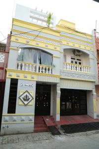 Edificio amarillo y blanco con balcón en La Maison Radha, en Pondicherry