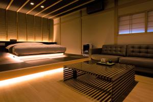 a bedroom with a bed and a couch and a table at HOTEL ZEN-Adult Only in Hirosaki